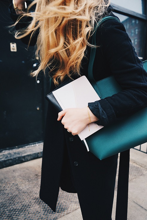 corporate woman holding purse and notebook